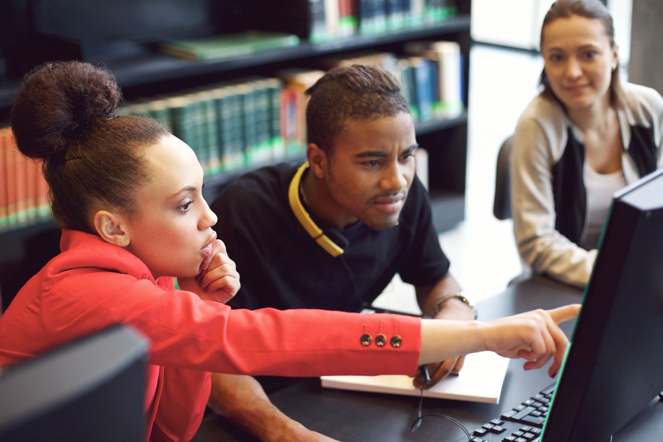 Students collaborating on research in a library